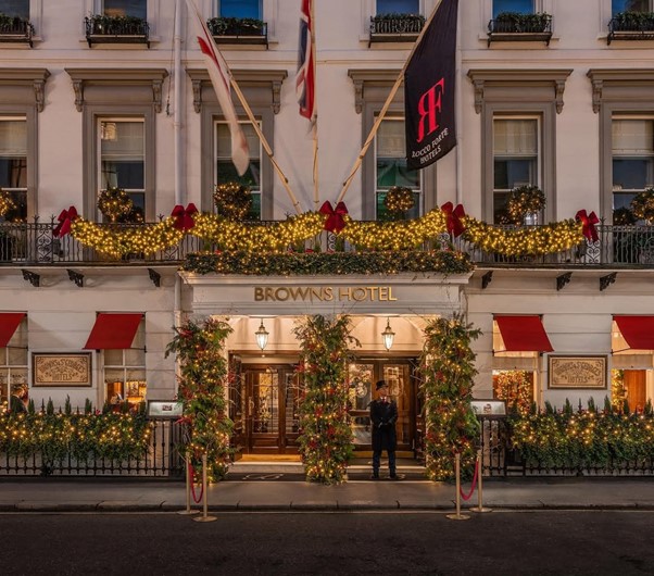 Browns Hotel Exterior With Christmas Decorations - Garland, Red Bows, Fairy Lights, Baubles, and a Porter